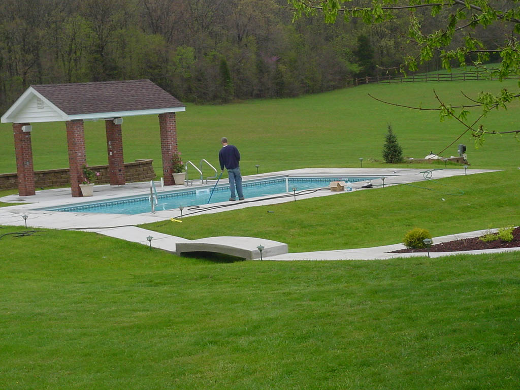 man cleaning pool - JNR Pools